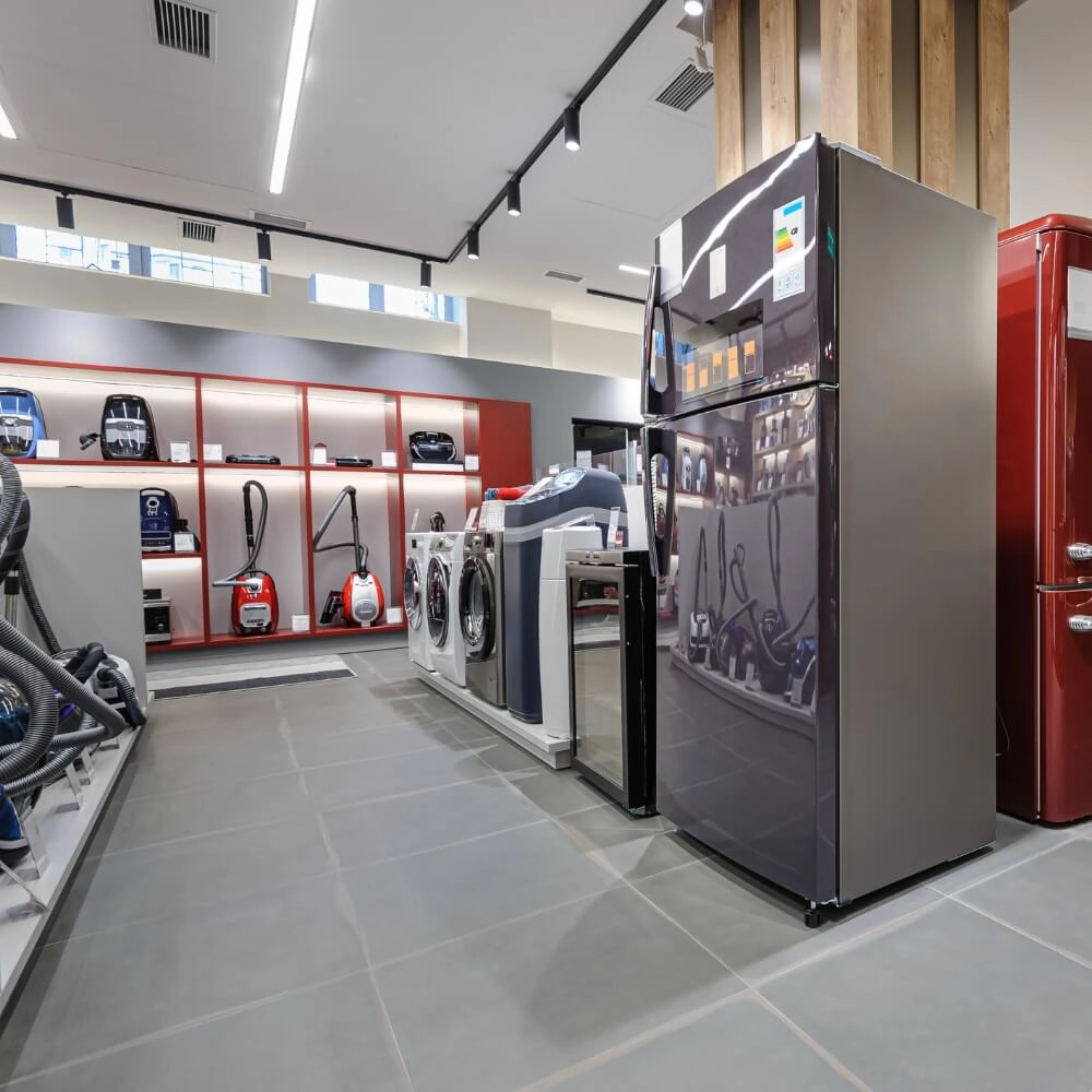 Sessão de eletrodomesticos de uma loja com aspiradores de pó, geladeiras e maquinas de lavar roupa